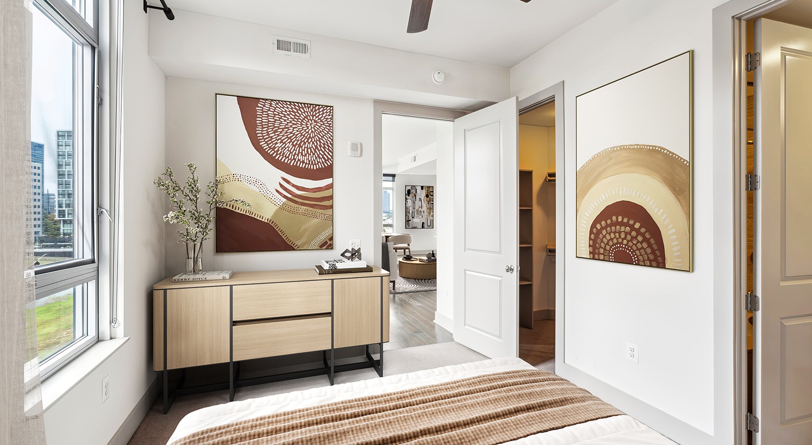 bedroom with dresser art on the walls and a window